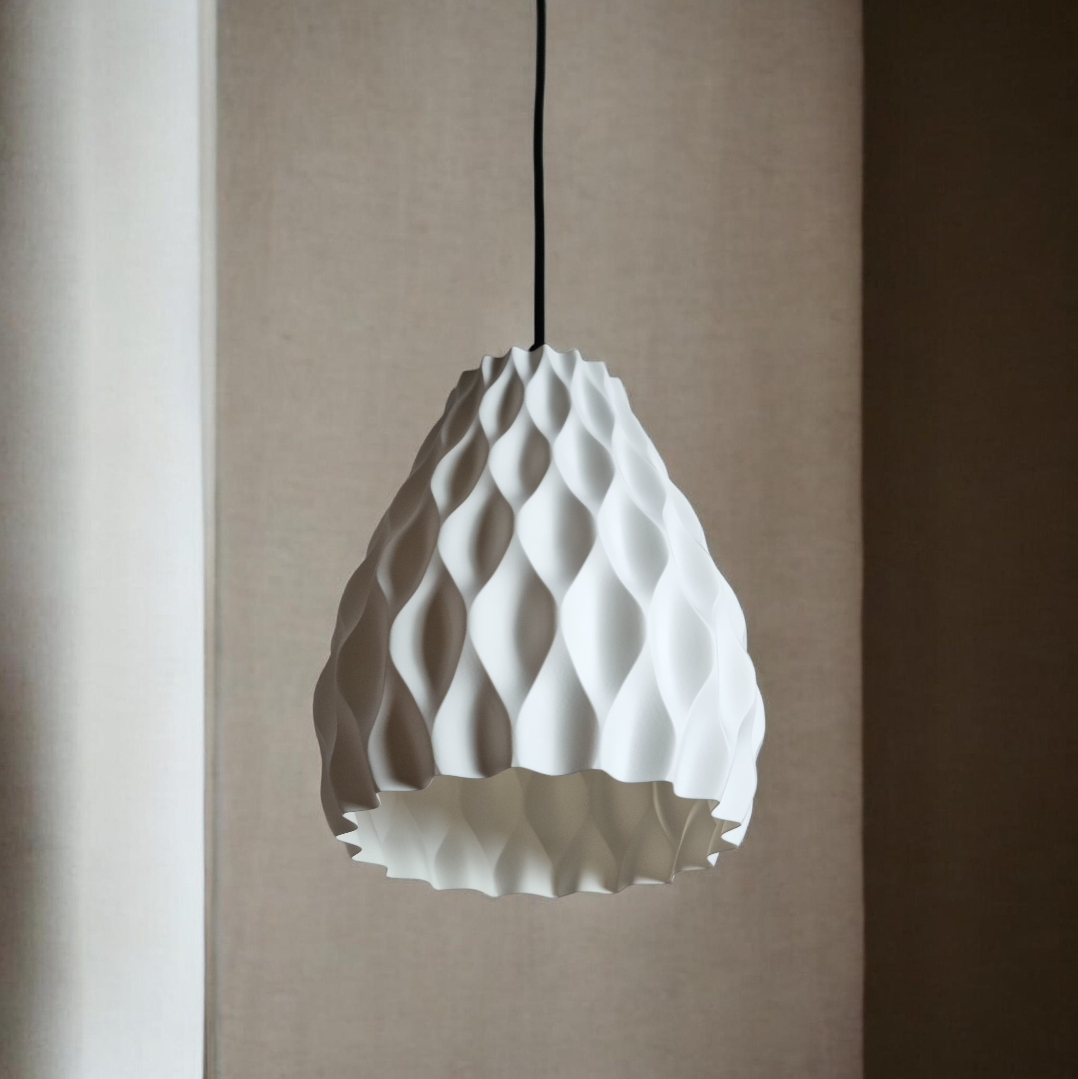 A textured white pendant light with an organic, faceted design hangs from a black cord against a neutral background. The lights three-dimensional surface creates interesting shadows and reflections, enhancing its aesthetic appeal.