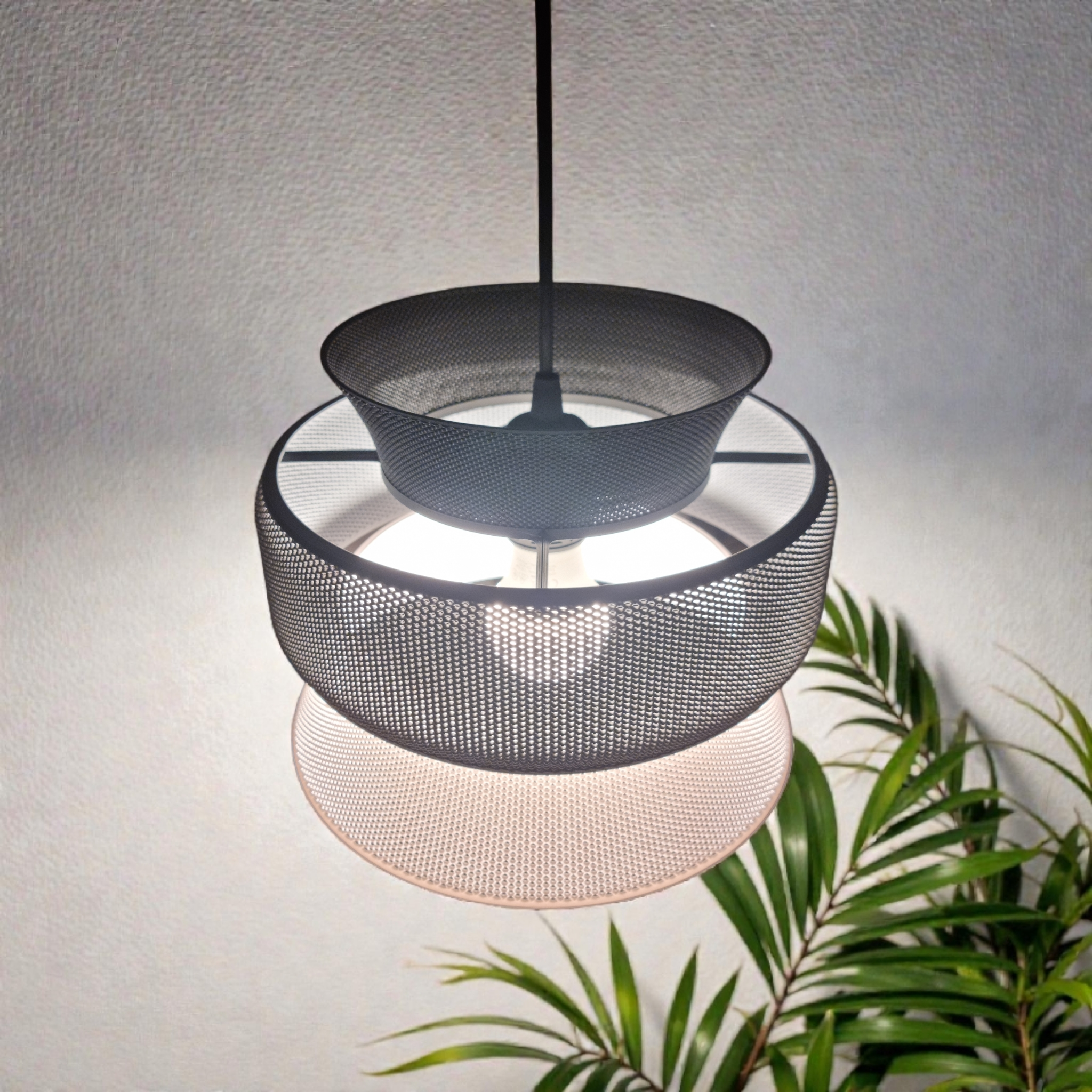 A modern pendant light featuring three interconnected mesh shades in varying sizes, creating a unique geometric design.