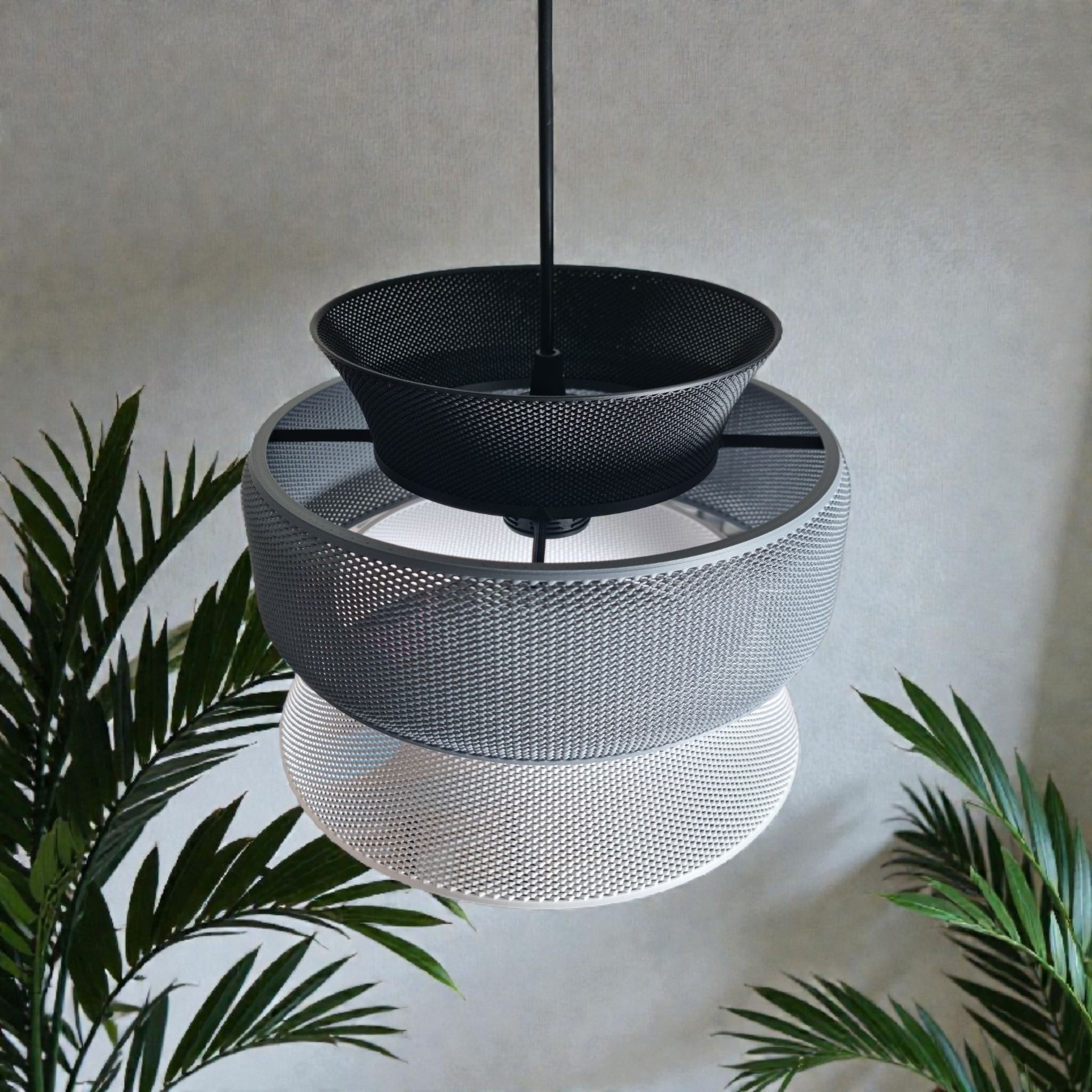 A modern pendant lamp features three interlocking mesh shades in black, gray, and white, creating a layered geometric design.