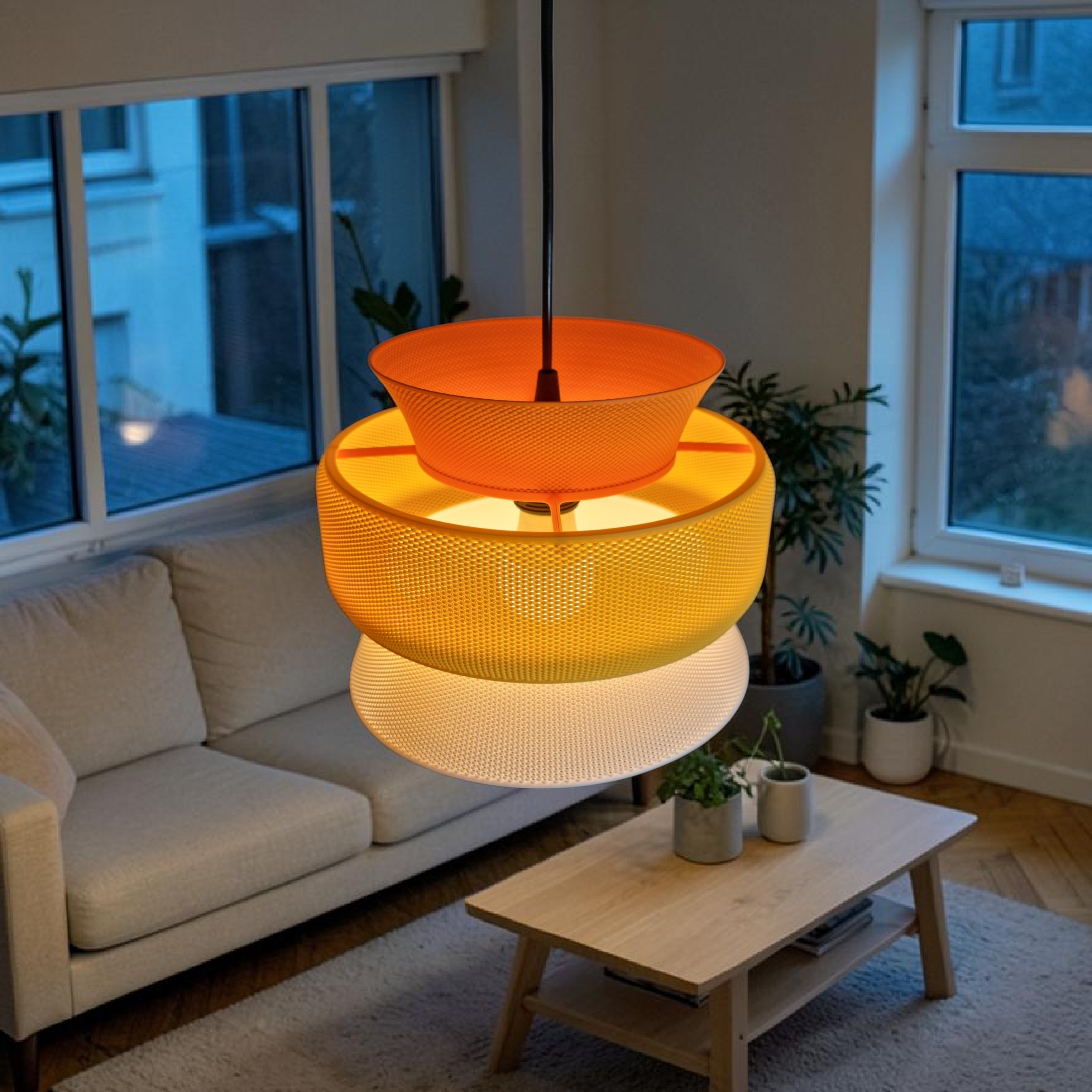 SAN pendant lampshade in plant-based bioplastic, orange yellow and white gradient, lit up in a living room setting with sofa and wooden coffee table