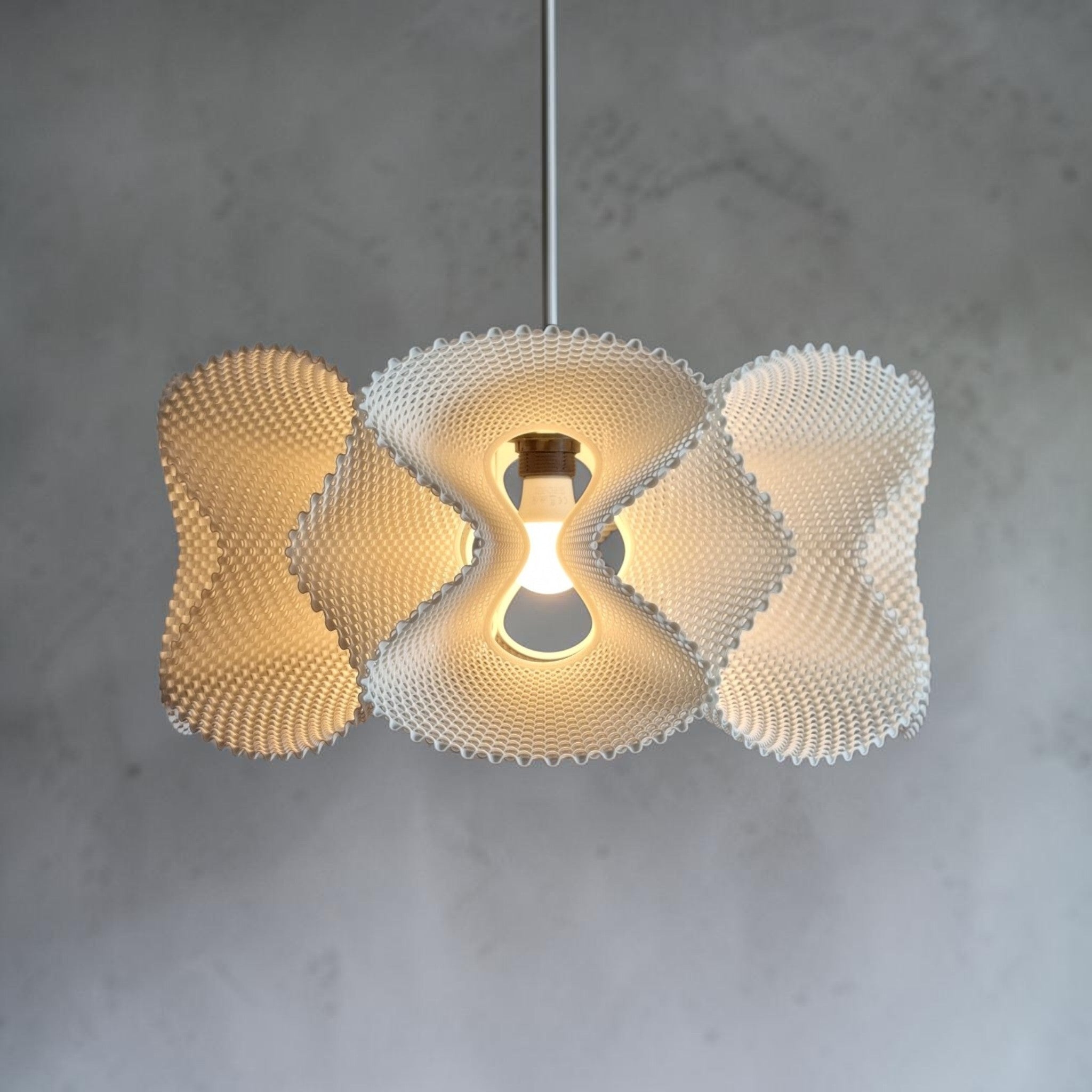 Abat-jour suspension COROA blanc, vue de face sur fond béton, texture perlée, ampoule LED E27, luminaire minimaliste Quarks