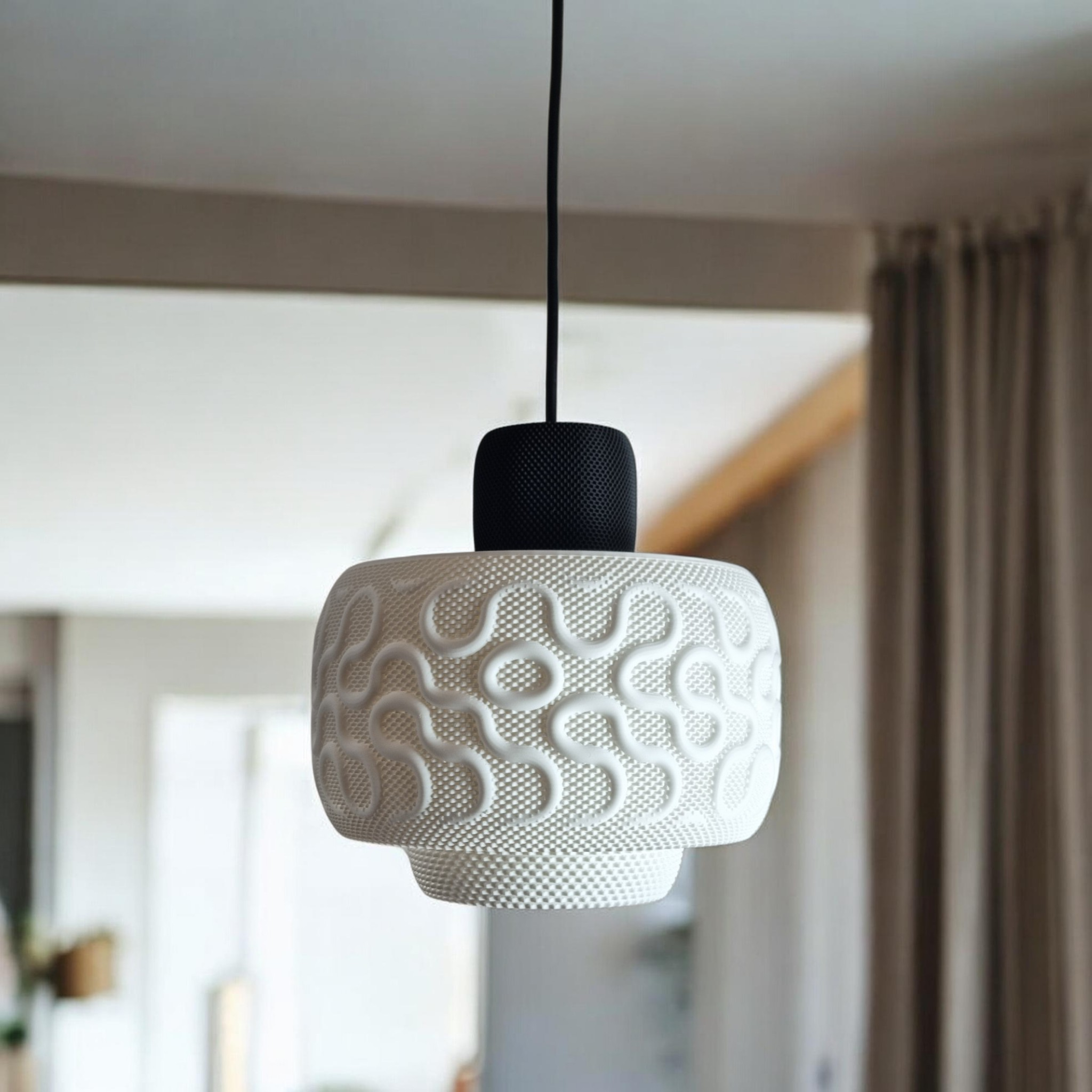 SEAMLESS matte white pendant light in a bright living room, showing the sculptural relief pattern and black textured socket cover