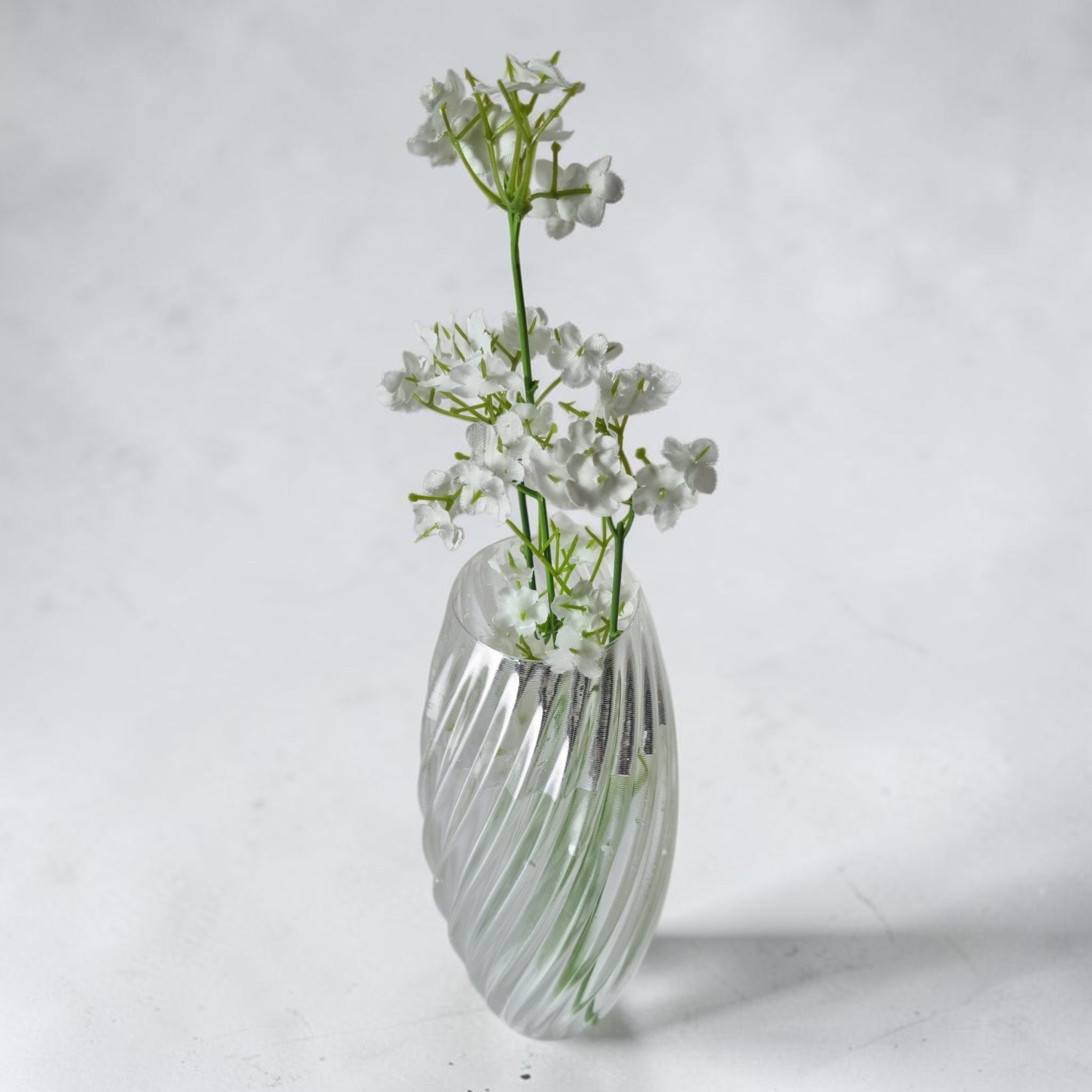 Transparent TEXTURIA vase filled with water and fresh white gypsophila flowers, showcasing its watertight design for fresh floral arrangements
