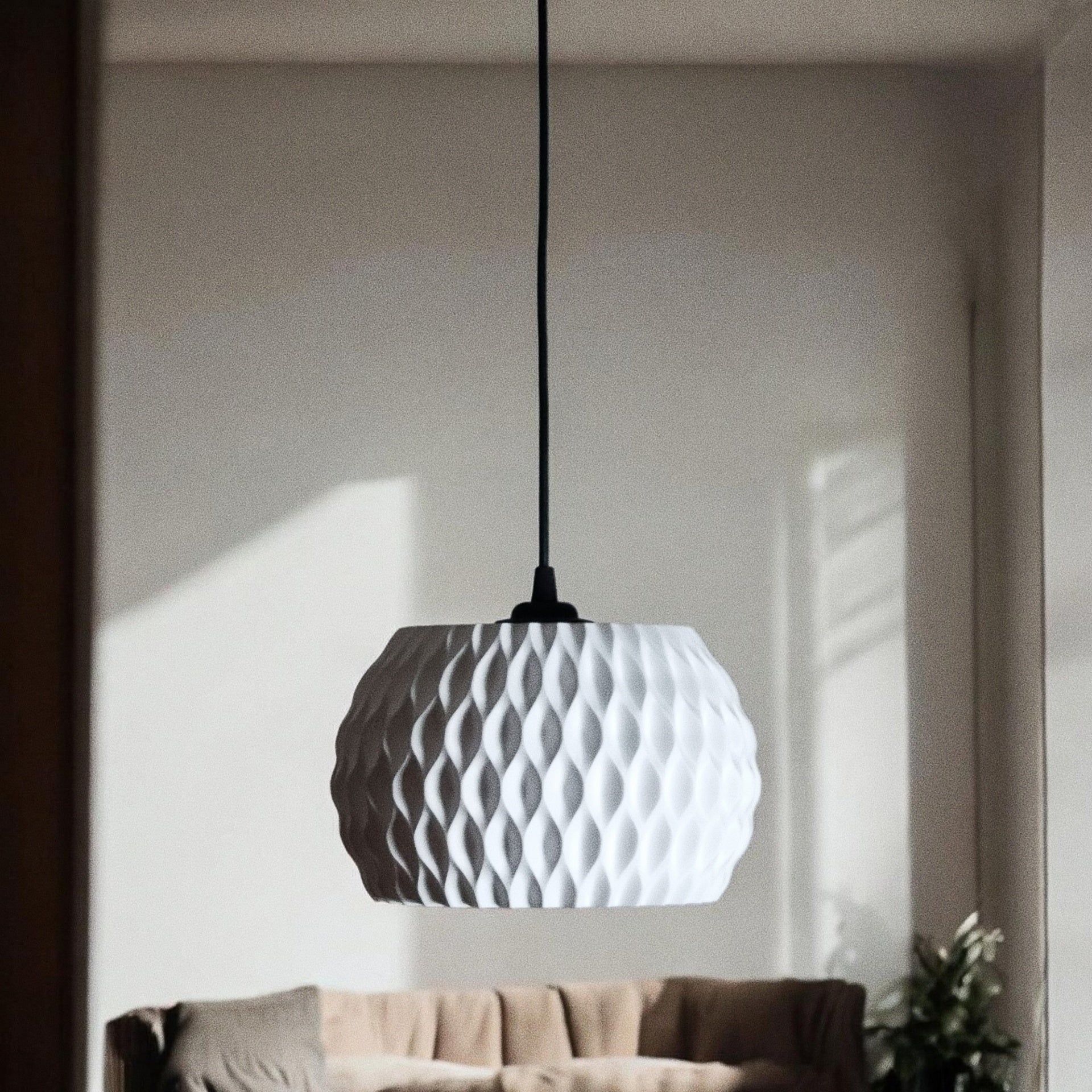 Abat-jour WAVY blanc éteint suspendu dans un salon, relief ondulé visible avec jeu d'ombres naturel